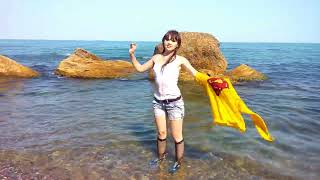 girl in wet clothes swims in the sea