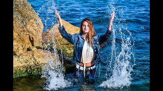 model girl in wet clothes swims in the sea