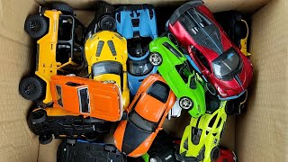 Box full of various miniature cars Peugeot, Jaguar, Pagani, Hyundai, Cadillac One, Opel, DHL