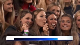 Girls smoking cigars near football