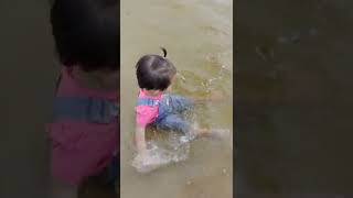 Adik bayi bermain air di pantai