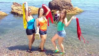 three beautiful girls get wet in their clothes in the ocean