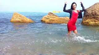 girl in a red dress gets wet in the sea