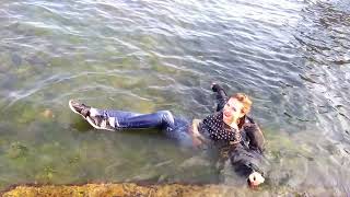 beautiful girl in wet clothes swims in the sea