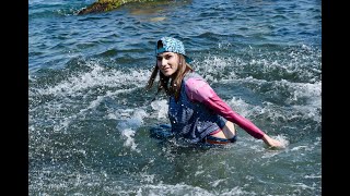 model in wet clothes swims in the sea