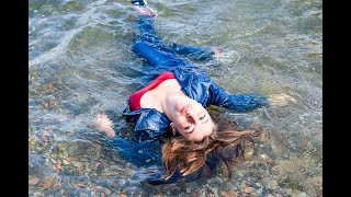 funny girl in clothes gets wet in the sea