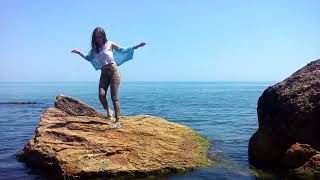 girl in clothes gets wet in water and swims in the ocean