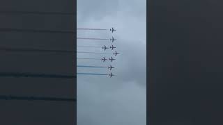 Red arrows soaring over Folkestone beach with red white and blue smoke