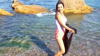 beautiful girl in clothes gets wet in the ocean