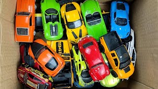 Box full of various miniature cars Peugeot, Jaguar, Pagani, Hyundai, Cadillac One, Opel, DHL