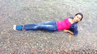 girl in jeans and a denim jacket gets wet in the sea