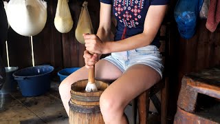 Life in mountains. Woman makes butter using old technology. Ukrainian Carpathians