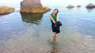 model in clothes swims in the sea