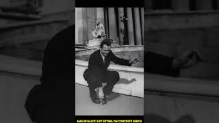 Historical photos man in black suit sitting on concrete bench