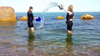 girls in clothes shower each other and then swim