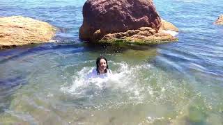 girl in clothes gets wet in the sea