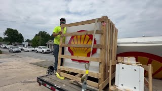 Josh Martin of Interstate Sign prepares to open the crate containing the new and smaller signs for