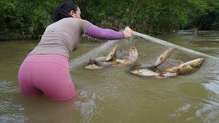 The girl cast a net into the stream during the flood season and caught many big fish