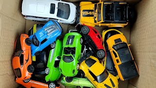 Box full of various miniature cars Peugeot, Jaguar, Pagani, Hyundai, Cadillac One, Opel, DHL