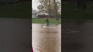 A man uses paddleboards in the flood area of Goleta.