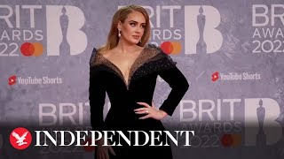 Adele poses on the red carpet as she arrives at the Brit Awards