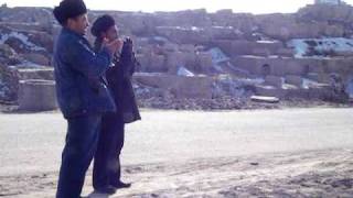 Uyghur men praying at graves near Yengisar