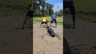 Two men sit beside a small paddy field