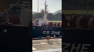 At the Panama Canal Miraflores locks up close. Crew members waving. CS ZHE Jiang ship going through