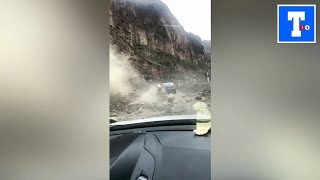 Scared motorist reverses as rocks tumble down mountain onto road below