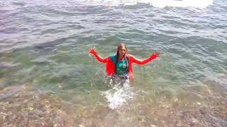 girl in clothes gets wet in the sea