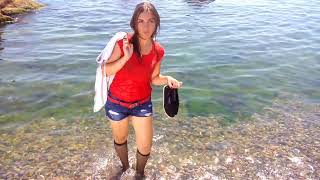 girl in wet clothes swims in the sea