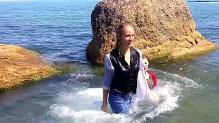 models get wet in the sea with their clothes on and play with each other